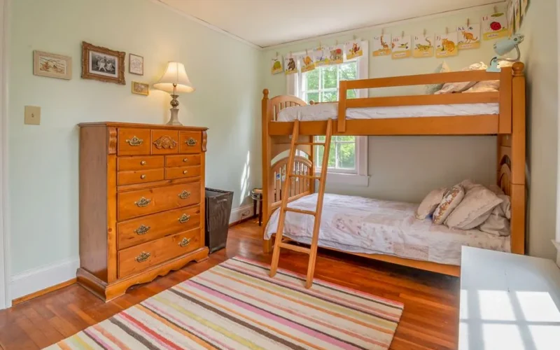 Warm and inviting children's bedroom featuring a classic wooden bunk bed and colorful decor.