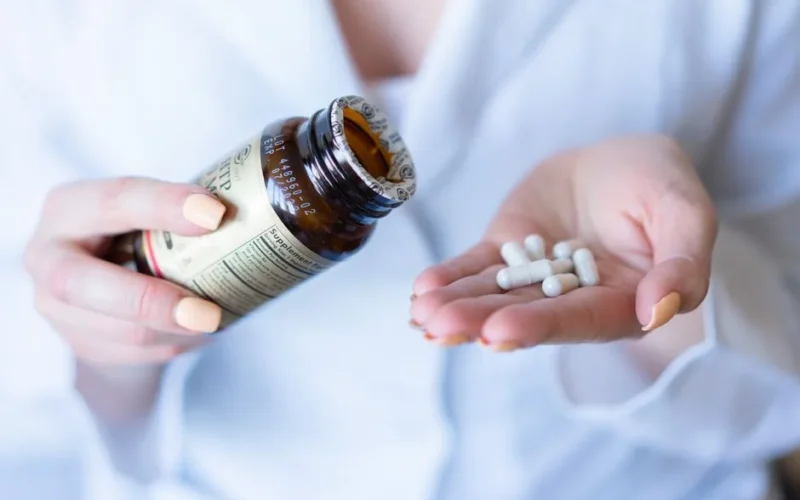 A close-up shot of hands holding a medicine bottle and pills, with a focus on healthcare and medication usage.