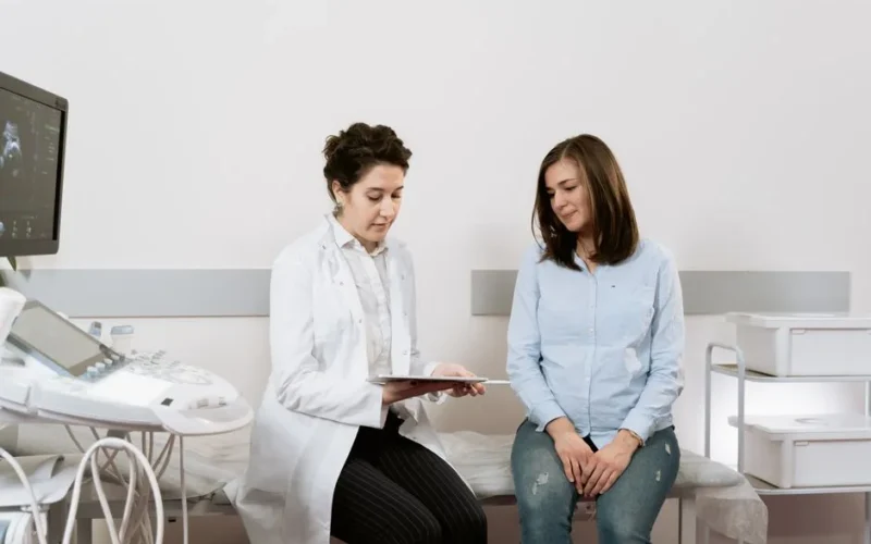 A pregnant woman consulting with a gynecologist in a medical facility.