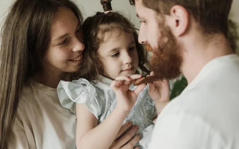 Close-up of a joyful family moment with parents and child indoors. Love and bonding.