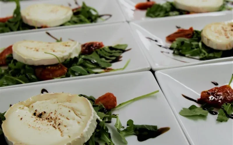 Plates of goat cheese with arugula and balsamic reduction, perfect for appetizers or a light meal.