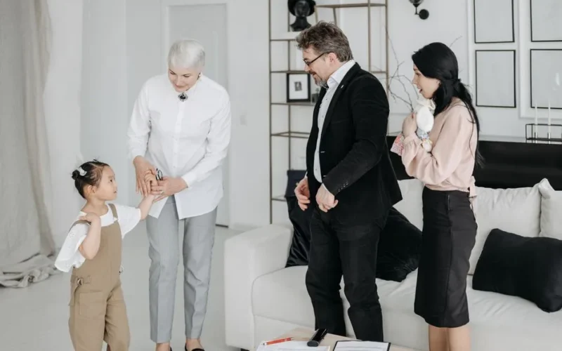 A joyful meeting of adoptive parents and child with a social worker in a modern interior.