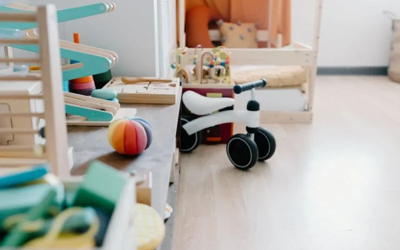 Bright and minimalistic children's playroom featuring wooden toys and balance bike for sustainable learning.