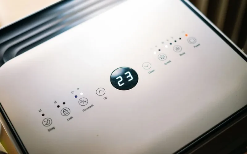 Close-up of a sleek air conditioner control panel displaying temperature.