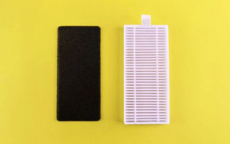 Black foam filter and white air filter on bright yellow backdrop showcasing air purification essentials.