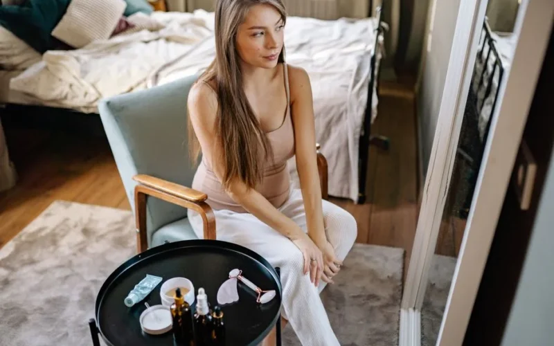 A pregnant woman enjoying her morning self-care routine with skincare products.