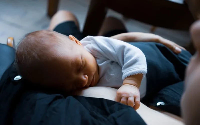 A serene image of a newborn baby peacefully sleeping on their mother's chest, capturing a moment of comfort and love.