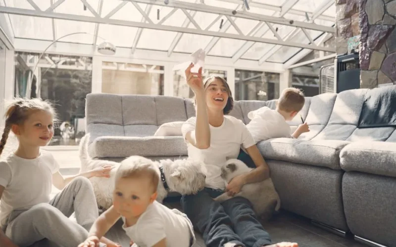A joyful family with children and pets having fun indoors, enjoying leisure time together.