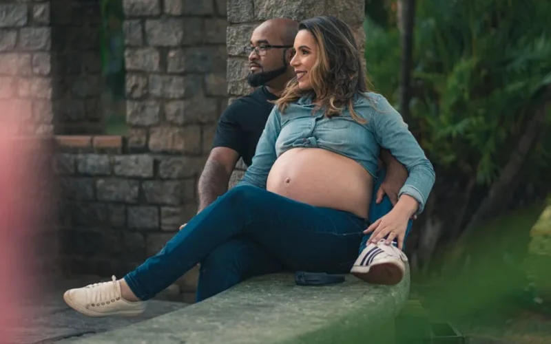 Pregnant woman and partner relaxing outside, showcasing love and anticipation.